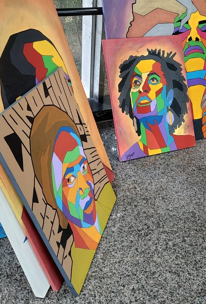 Outras obras da exposição Outros quadros da exposição, dispostos em pé, encostados próximo à janela.
