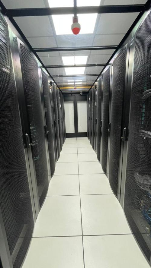 Foto do novo data center da Ufes, com um corredor central e equipamentos nas laterais
