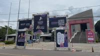 Imagem do Teatro Universitário e, à frente, um portal metálica com os cartazes de divulgação dos eventos.