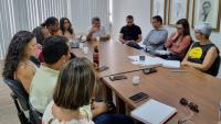 Foto da sala de reuniões, com gestores da Ufes e representantes da Adufes em volta da mesa.