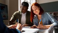 Estudante negro e estudante branca estudando em uma mesa