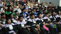 Foto da formatura da primeira turma do Prolind. Auditório cheio com os formando trajando beca e acessórios indígenas ocupando as primeiras cadeiras.