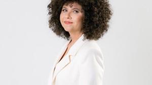 Foto da cantora Roberta Campos em pé, vestindo terno branco, em um ambiente igualmente branco