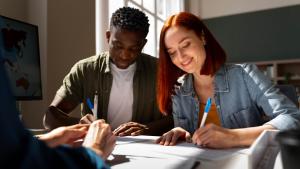 Estudante negro e estudante branca estudando em uma mesa