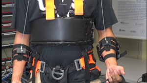 Homem vestido com o exotraje Homem em pé, vestido com o exotraje, que se assemelha a um colete de segurança