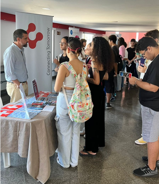 Estudantes ouvindo informações em um estande de agência, no hall do Teatro Univesitário