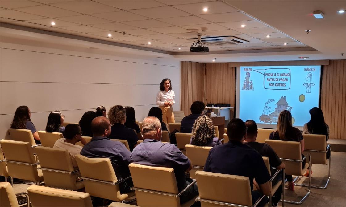 Pessoas assistindo a uma palestra do projeto, sentadas em um auditório.