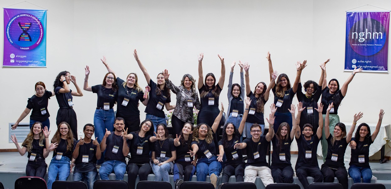 Foto dos integrantes da liga reunidos, todos vestindo camisas pretas e com os braços para cima, em comemoração