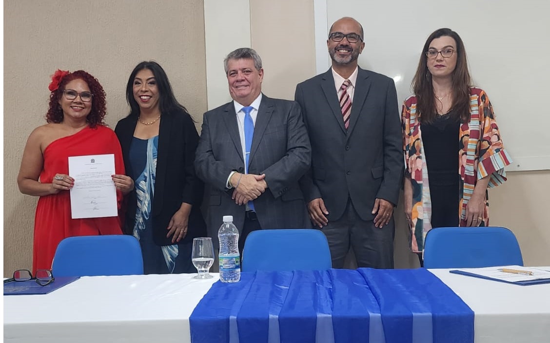 A diretora Lousiane Nunes, com o termo de posse, a vice-reitora, Sonia Lopes, o reitor Eustáquio de Castro, o vice-diretor Giovanni Garcia e a pró-reitora de Gestão de Pessoas, Josiana Binda. 