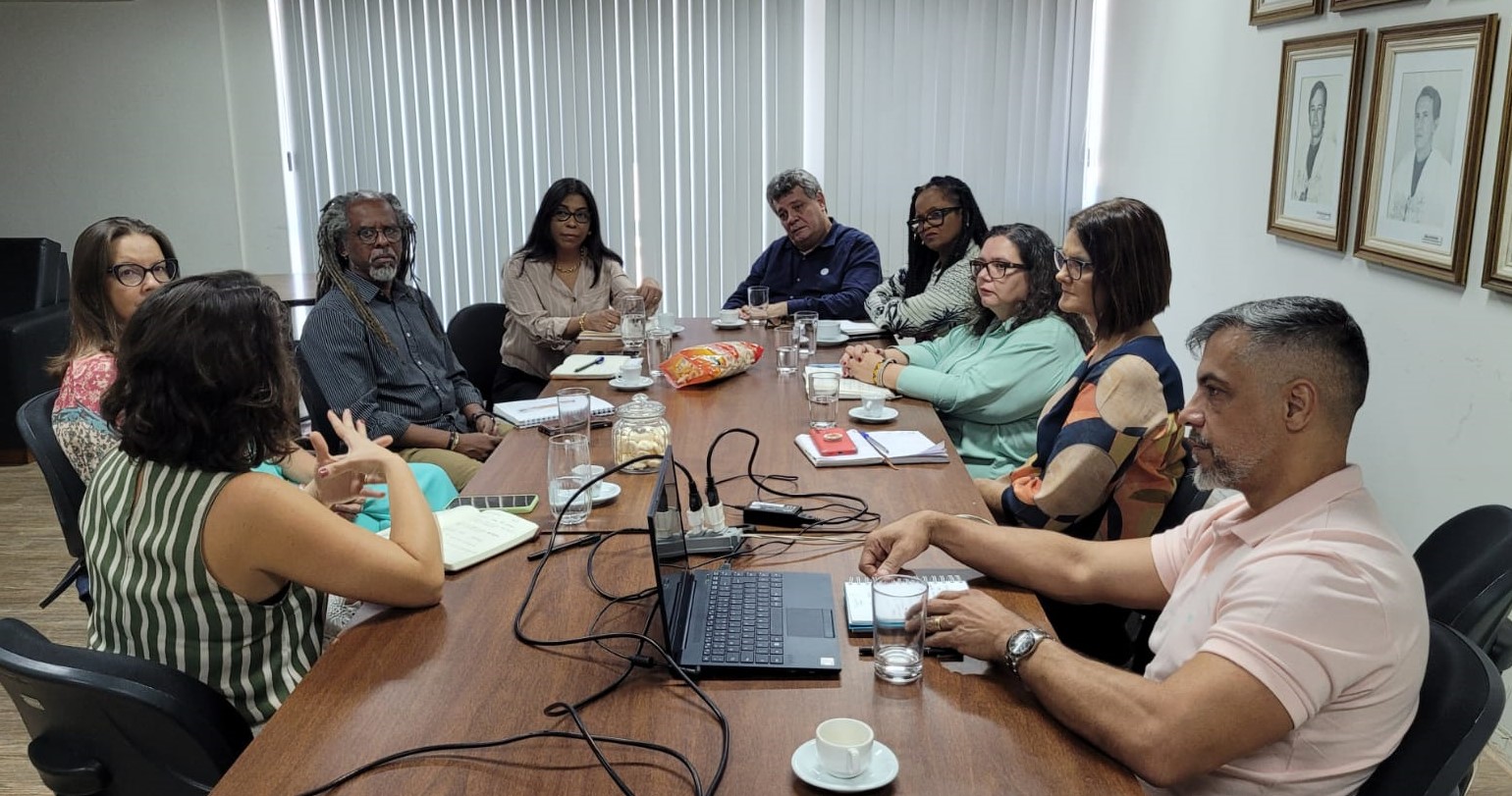 Foto da reunião, com todos os participantes sentados em volta da mesa.