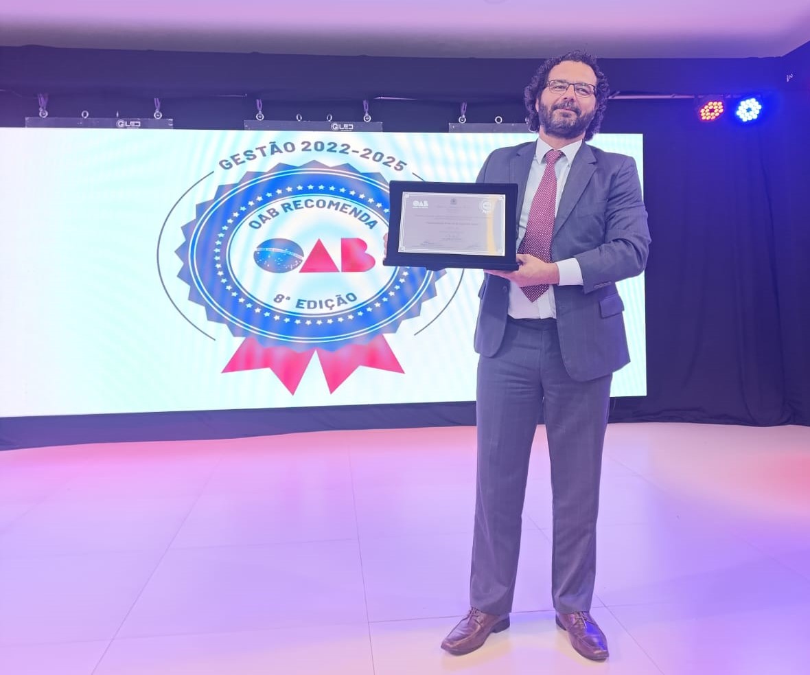 Foto do professor Tiago Gonçalves com a placa do selo OAB Recomenda