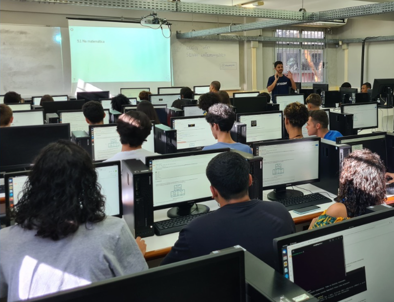 Foto de uma aula com os alunos no laboratório de informática