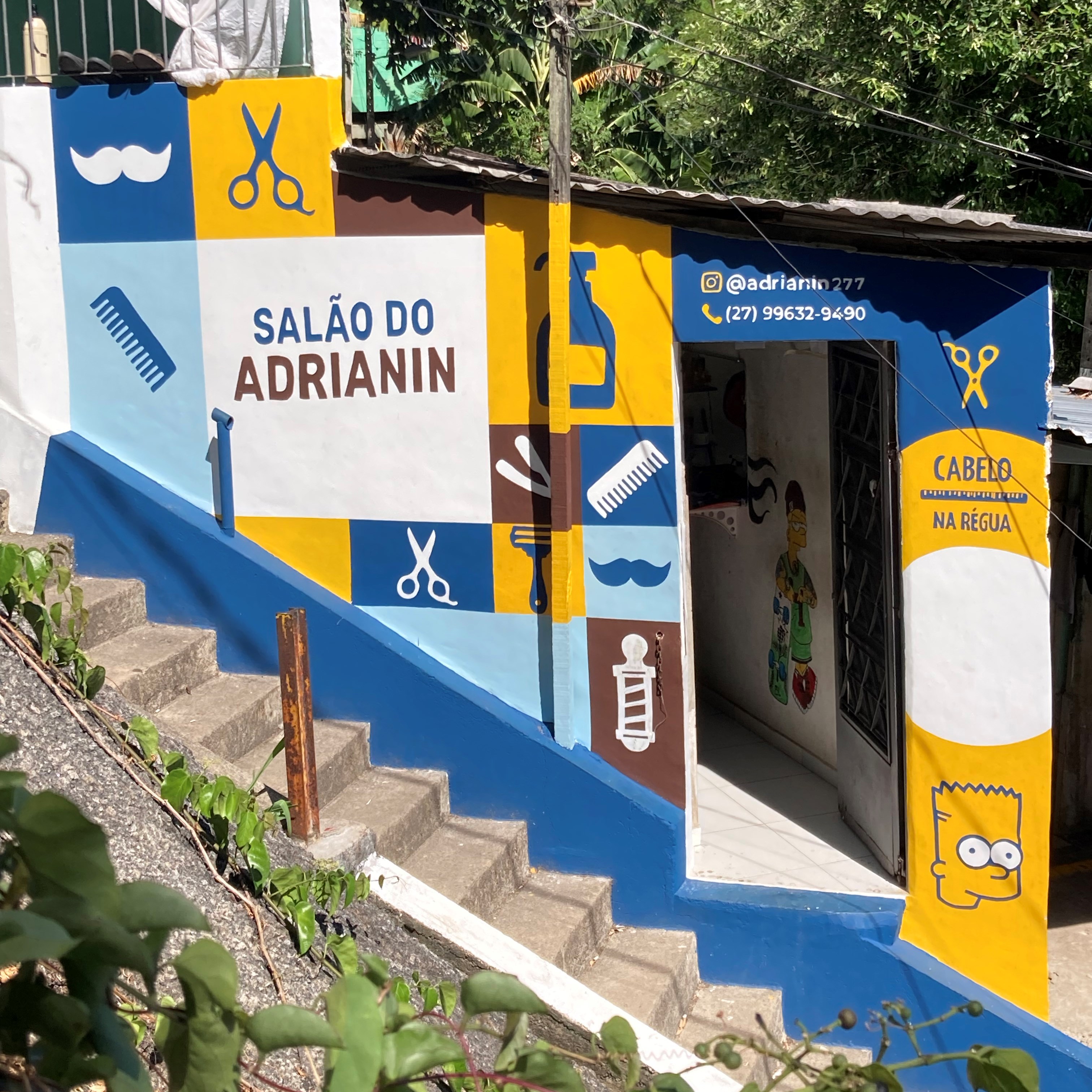 Foto da fachada de um salão de cabeleireiro masculino pintada nas cores azul e amarelo, após a revitalização  