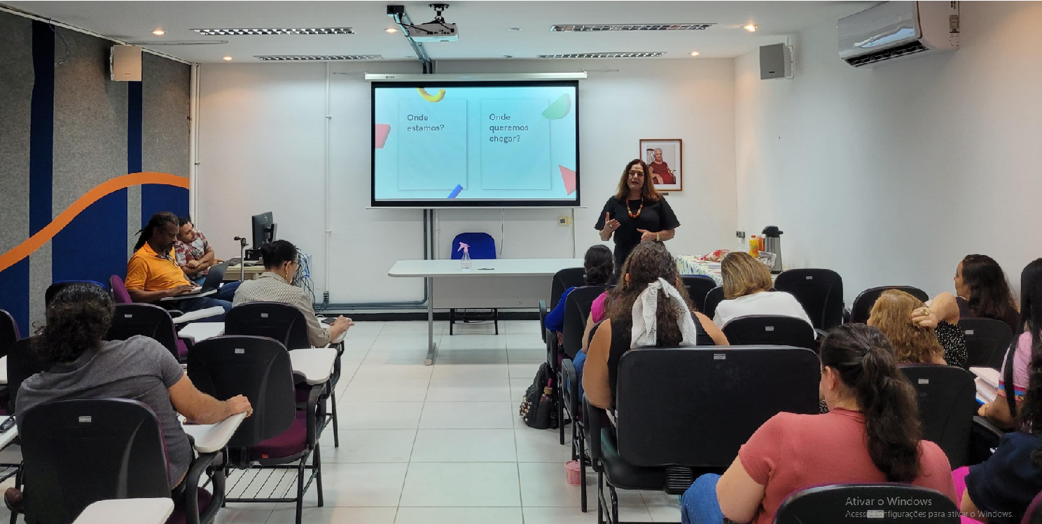 Foto da sala do seminário, com a diretora de Assistência Estudantil à frente, falando para os servidores