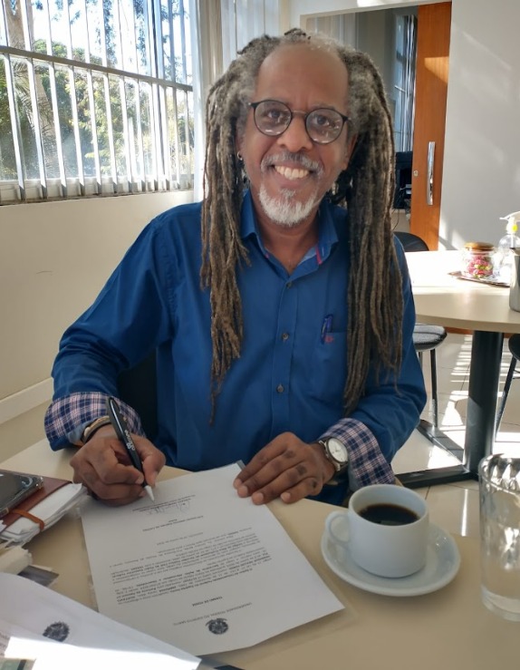 Foto do professor Gustavo Forde em sua mesa de trabalho