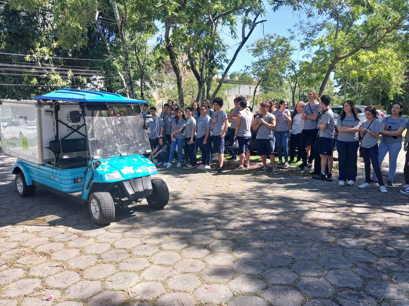 Foto dos estudantes conhecendo o carro autônomo