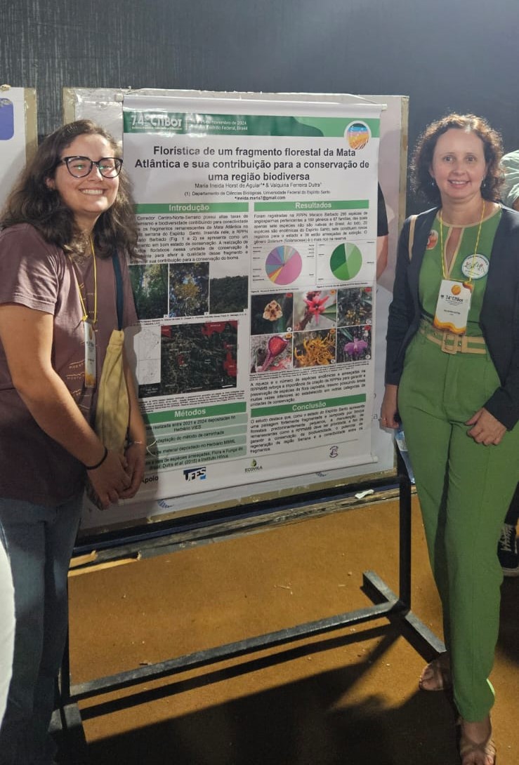 Foto da estudante e da professora ao lado do poster apresentado 