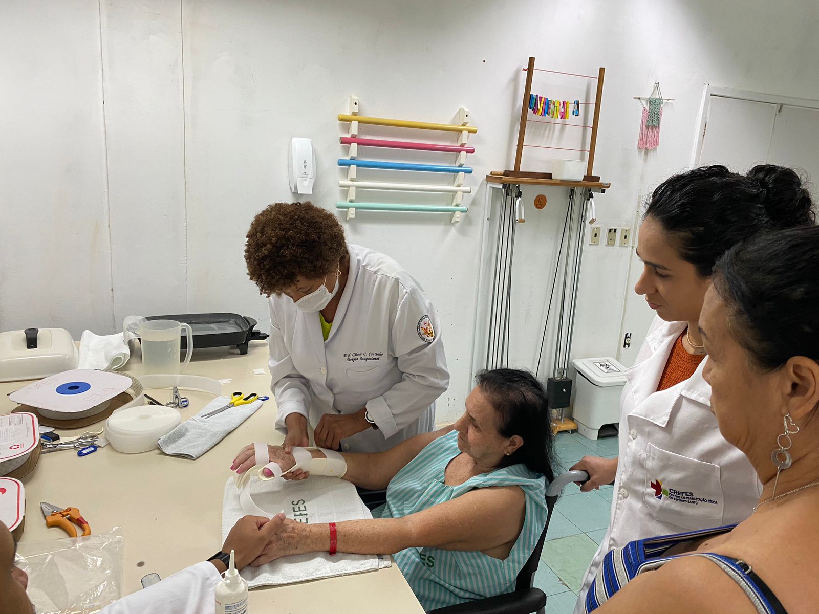 Foto da professora atendendo a uma senhora em um ambiente de reabilitação