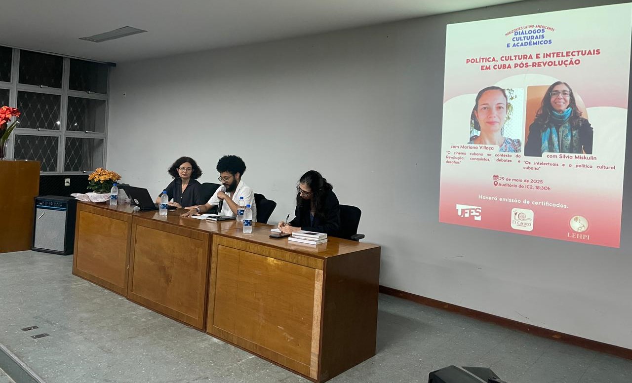 Foto da mesa com as duas pesquisadoras e um mediador