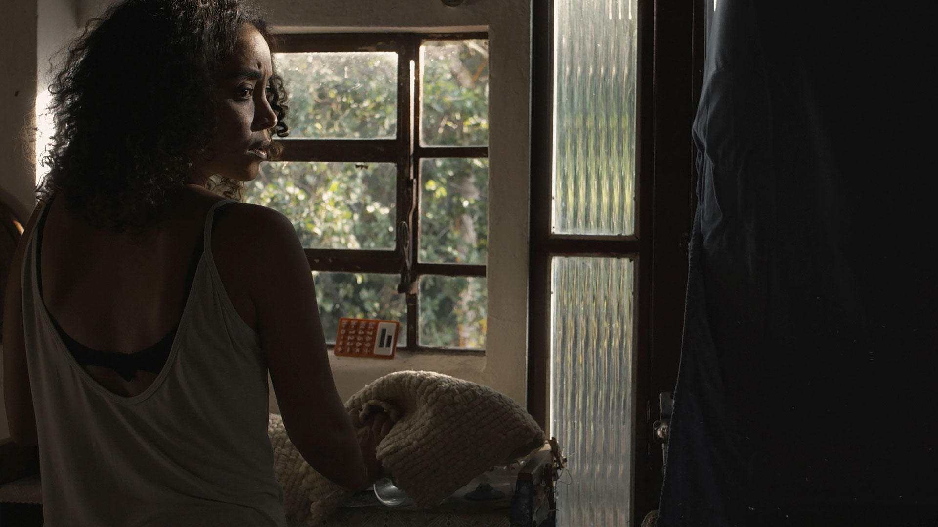 Cena do filme Inventário de Imagens Perdidas, onde aparece uma mulher de frente para uma báscula, olhando para o lado
