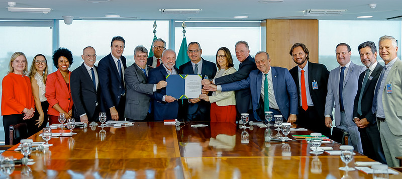 Foto de todas as autoridades presentes na sala de audiência, mostrando a portaria assinada