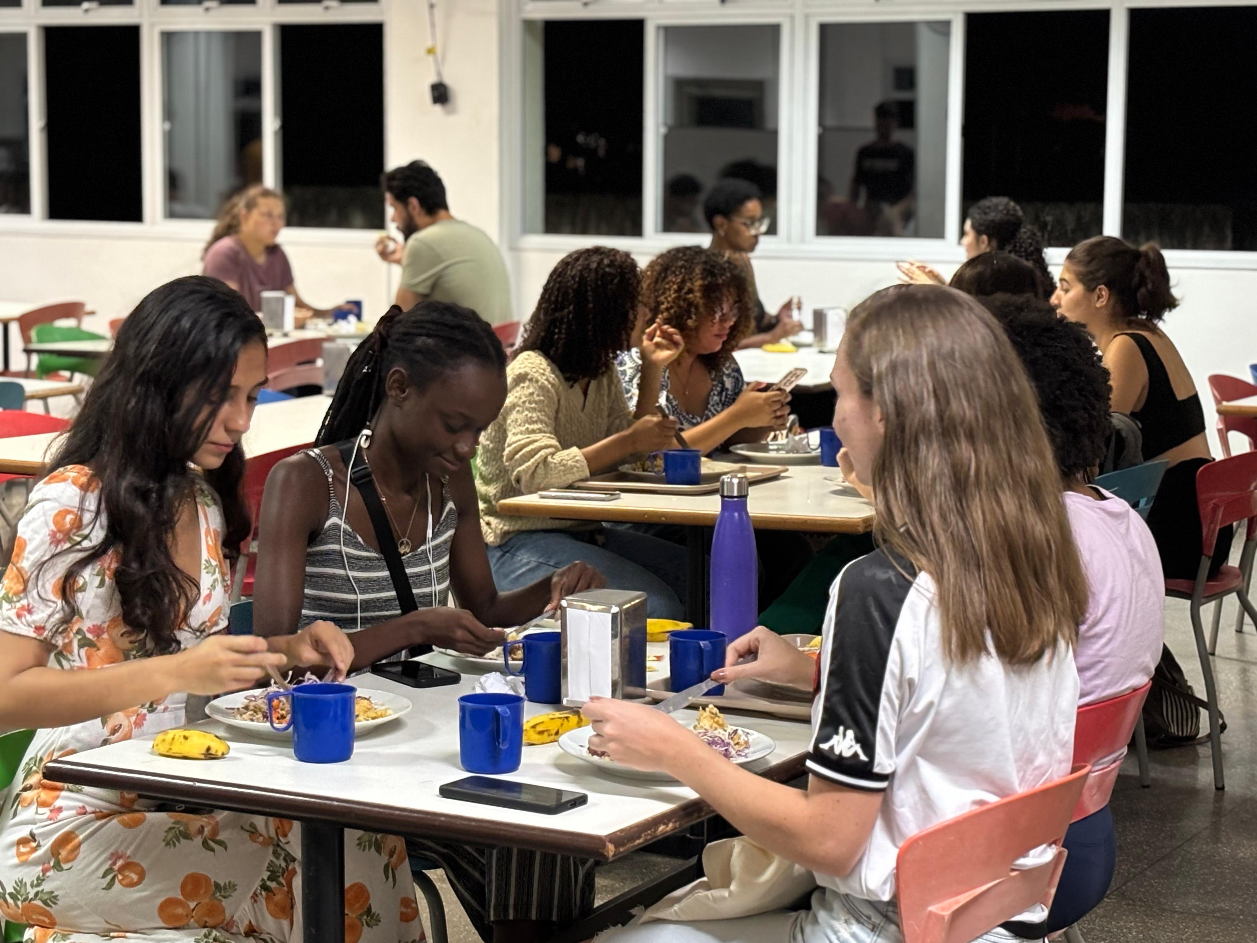 Foto de um grupo de estudantes jantando no RU