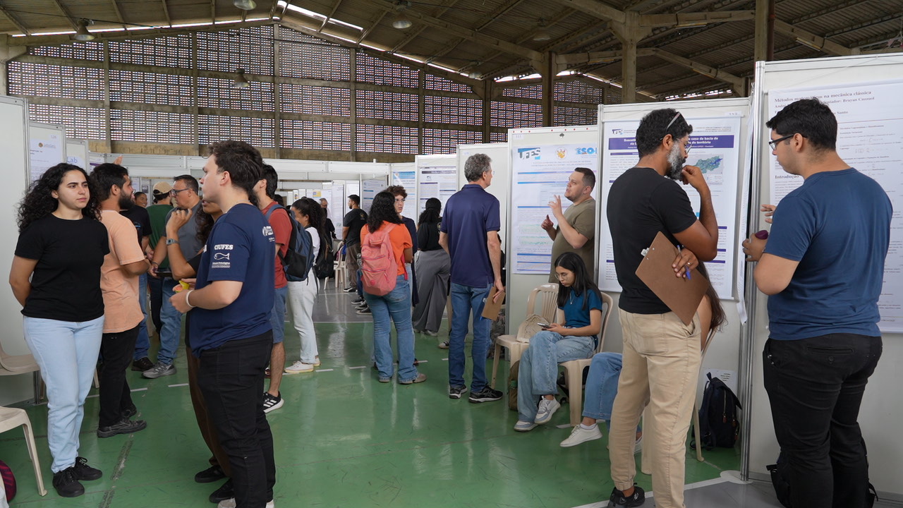 Vista geral do local, com várias pessoas olhando os banners