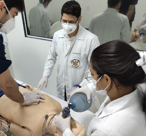 Foto de profissionais de saúde treinando um procedimento em um boneco