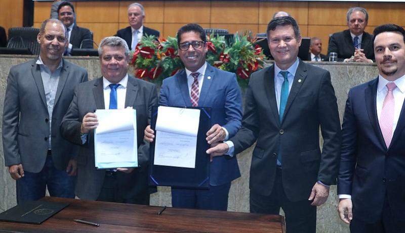 O reitor e o presidente da Ales mostram o protocolo de intenções assinado, ao lado das testemunhas.