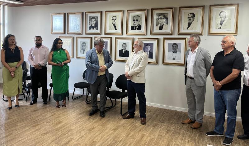 Foto do reitor Eustáquio de Castro falando ao ex-reitor Paulo Vargas diante dos demais gestores.