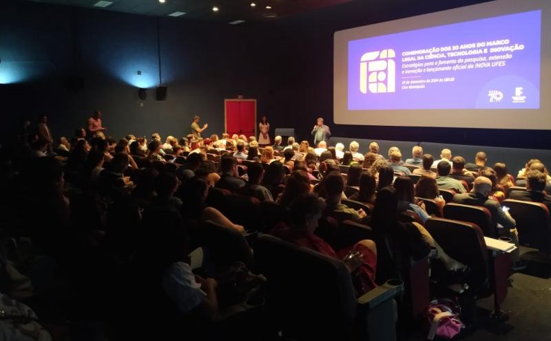Foto do reitor Eustáquio de Castro falando para a plateia no Cine Metrópolis lotado.