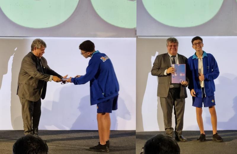 O reitor recebendo um exemplar do plano das mãos do estudante Arthur Menezes