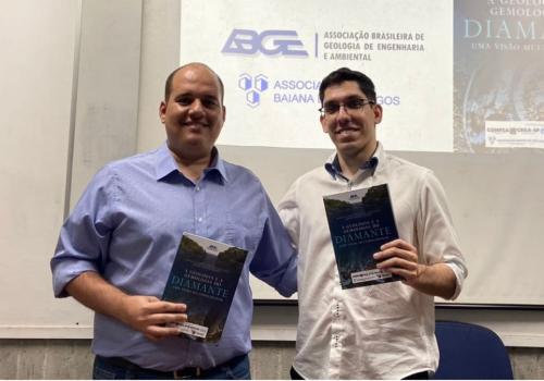 Os autores posam para a foto segurando um exemplar do livro