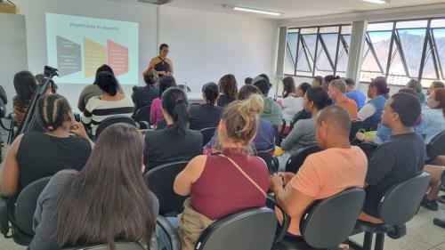 Foto dos trabalhadores em uma sala, assistindo a uma palestra