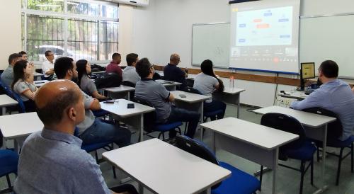 Grupo de pessoas assistindo a uma apresentação em uma sala
