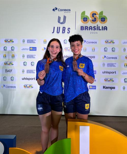 Foto das estudantes Amanda e Nadine mostrando suas medalhas conquistadas nos Jogos Universitários