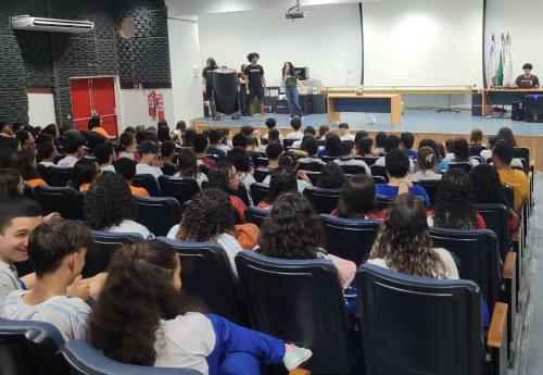 Foto do auditório do CCE cheio de estudantes assistindo a uma apresentação