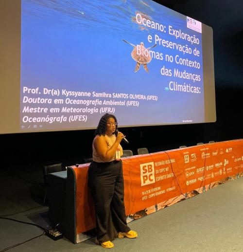 Foto da professora Kyssyane Oliveira na conferência Oceano - exploração e preservação de biomas