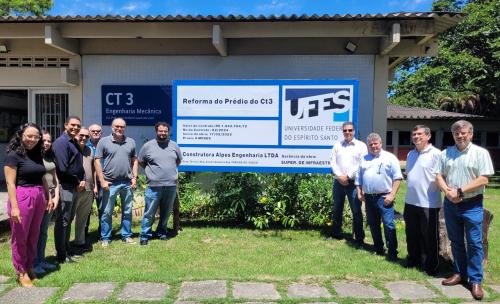 Foto do reitor, diretores do centro e servidores da Superintendência de Infraestrutura em frente à placa de reforma do prédio