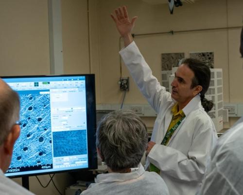 Foto do biólogo Jehová Lourenço Junior em um laboratório, com outros pesquisadores