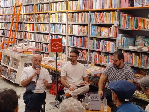 Foto de Wilberth Salgueiro, Nelson Martinelli e Marcelo Ferraz em uma livraria, sentados, falando sobre o livro