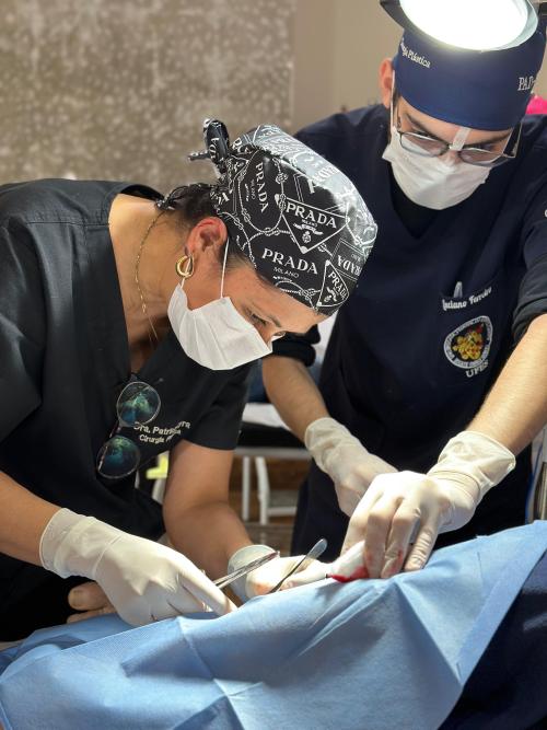 Foto de dois cirurgiões operando uma pessoa