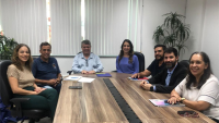 Na foto, os participantes da reunião sentados em volta da mesa.