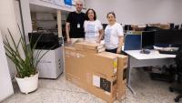 O coordenador do Polo de Baixo Guandú, Marcio Guilherme Marques, a superintendente de Educação a Distância, Maria Auxiliadora Corassa, e a diretora Acadêmica, Andreia Lins, posam com as caixas dos equipamentos na sala da Sead.