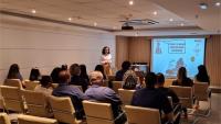 Pessoas assistindo a uma palestra do projeto, sentadas em um auditório.