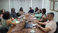 Foto da reunião, com todos os participantes sentados em volta da mesa.