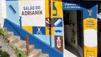 Foto da fachada de um salão de cabeleireiro masculino pintada nas cores azul e amarelo, após a revitalização  