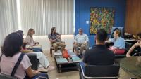 Foto da reunião, com todos os participantes sentados no gabinete do reitor