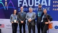 Foto da equipe da SRI com o reitor da Ufes em frente a um painel da Faubai