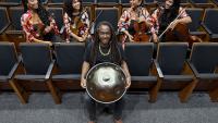 Foto do músico Luccas Martins segurando o handpan e o Quarteto Zuri